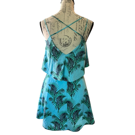 Back of blue dress with palm leaf pattern on a mannequin against a white background