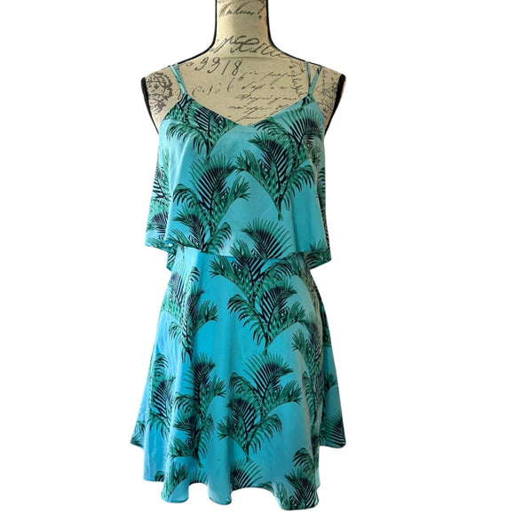 Blue dress with palm tree pattern on a mannequin against a white background
