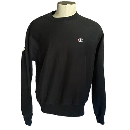 Front of Black sweatshirt with a small logo on a mannequin against a white background