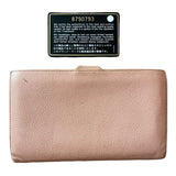 Pink wallet with a certification label on a white background