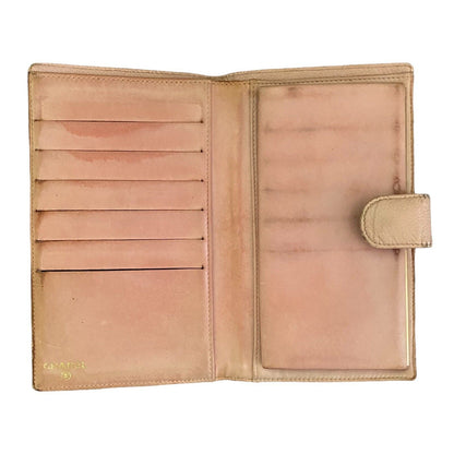 An open vintage pink leather wallet with multiple card slots on the left and a slip pocket on the right, featuring a small gold 'CHANEL' logo on the bottom left.