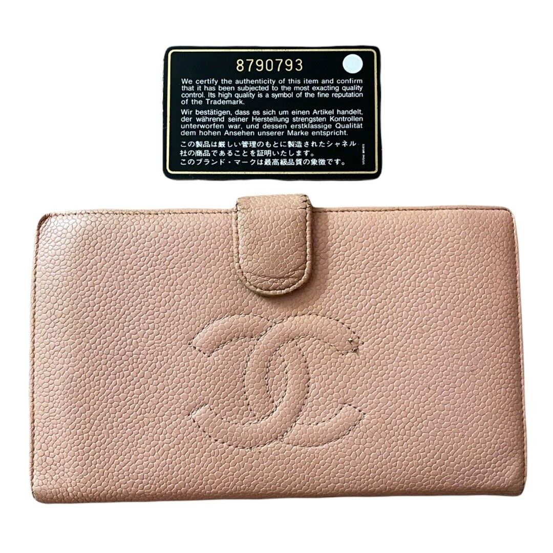 Pink wallet with Chanel logo and a certification label on a white background
