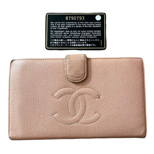 Pink wallet with Chanel logo and a certification label on a white background