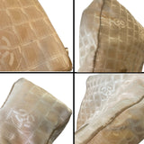 Four quadrant view of a textured beige fabric with CC patterns with stains and dirt marks