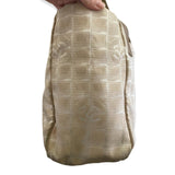 Side of Beige patterned bag held by a hand on a white background