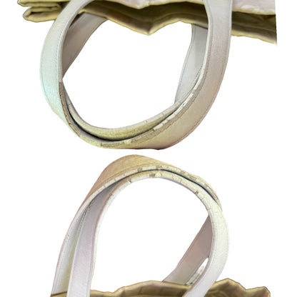 Close-up of a off white beige tote bag handle with a light cream interior lining, shown against a plain white background in two stacked views.