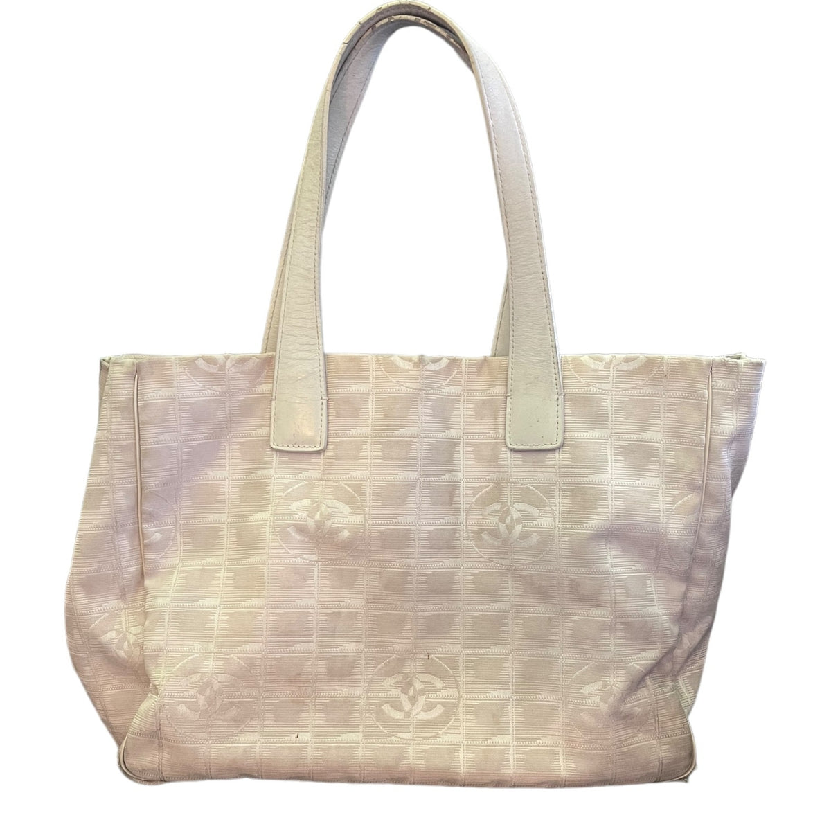 A light beige tote bag with a subtle embossed grid pattern and matching beige shoulder straps, shown against a plain white background.