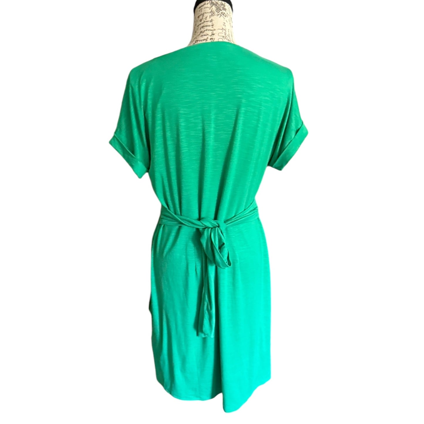A  green short-sleeve dress with a tie waist belt, shown from the back on a mannequin against a plain white background.