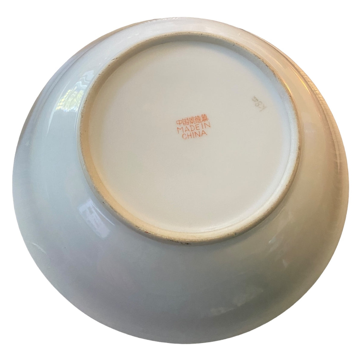 The underside of a bowl with a glossy glaze, showing a red Chinese 'MADE IN CHINA' mark on a white background.