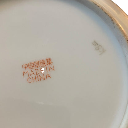 Close-up of the bottom of a white bowl, showing orange printed text reading '中国景德镇 MADE IN CHINA' and a gray mark reading 'K8X'.