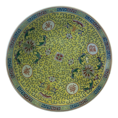 A round yellow bowl with intricate floral motifs, Chinese characters in red circles, and a blue and gold geometric border.