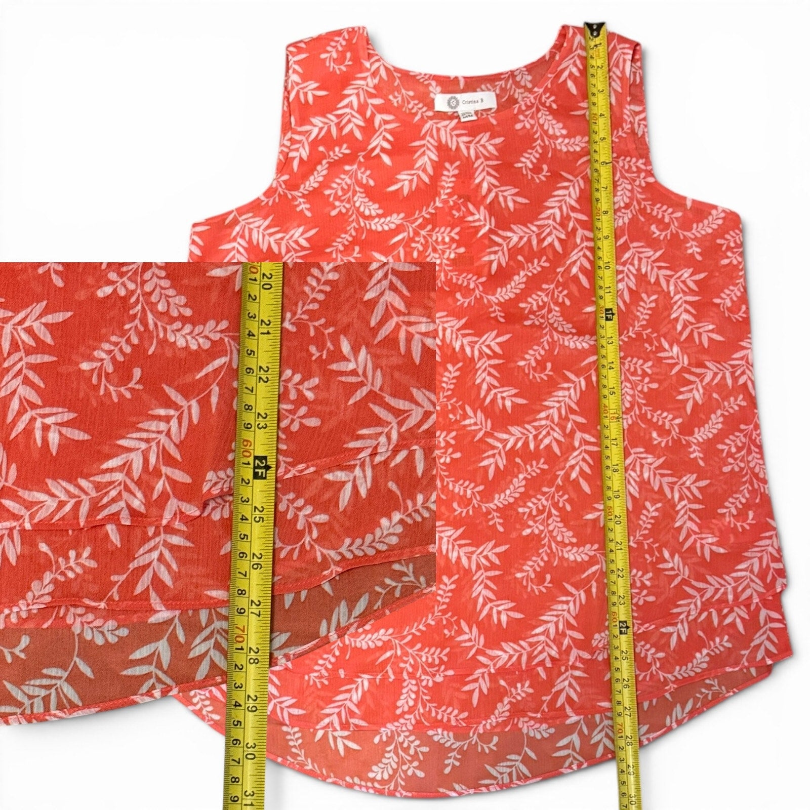 Pink sleeveless top with white leaf pattern and a measuring tape on a white background