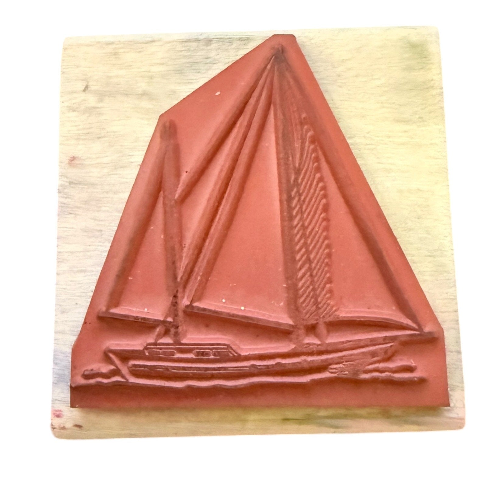 Red sailboat stamp on a wooden block