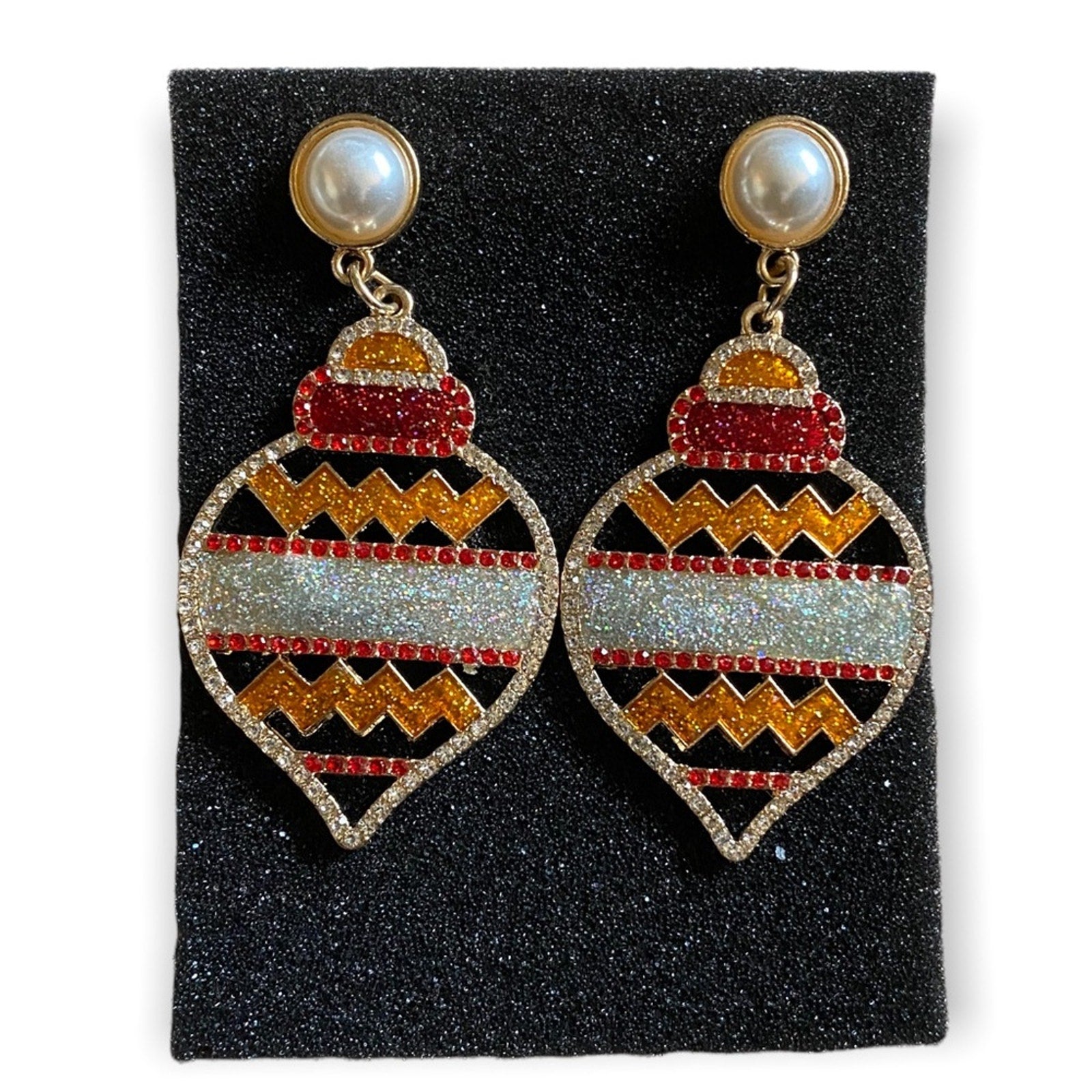 Pair of earrings with holiday design on a black foam
