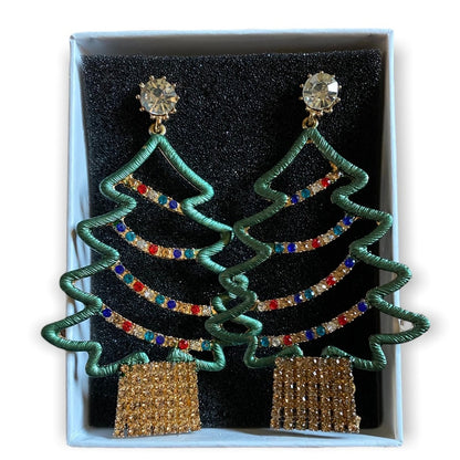 A pair of Christmas tree-shaped drop earrings displayed in a light blue gift box with a black foam insert. Each earring has a green outlined tree shape adorned with rows of multicolored rhinestones, a clear faceted crystal stud at the top, and a gold-toned rectangular base covered in small rhinestones.
