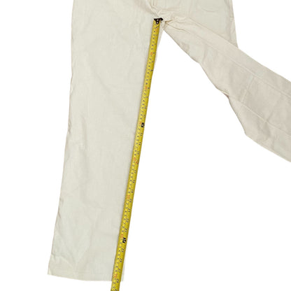 Off white pants with a tape measure running along the leg on a white background