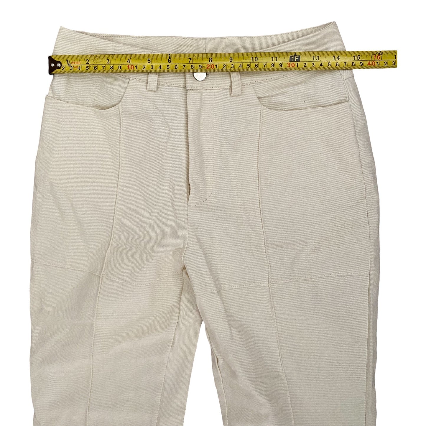 Off white pants with a measuring tape on a white background