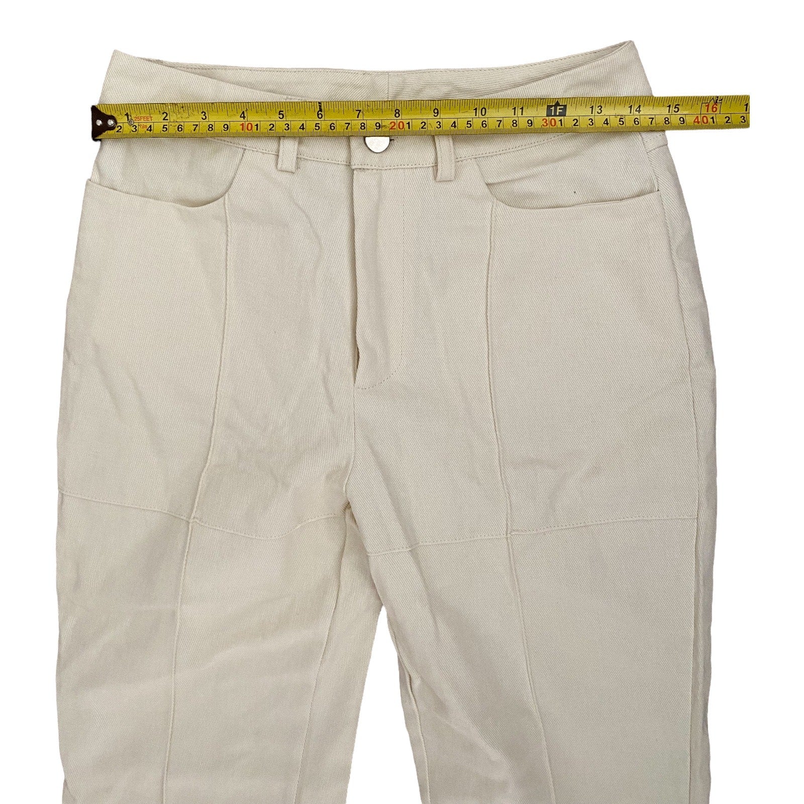 Off white pants with a measuring tape on a white background