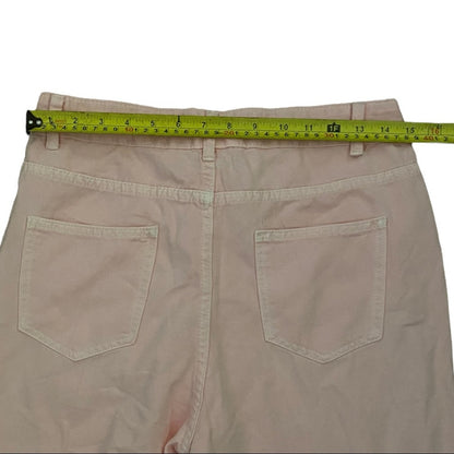 Back view of light pink pants with two back pockets and a yellow tape measure stretched across the waistband to show the measurement.