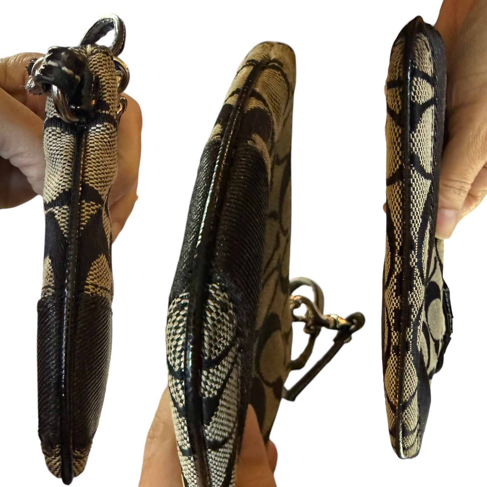 Side views of Coach wristlet held by a hand on a white background
