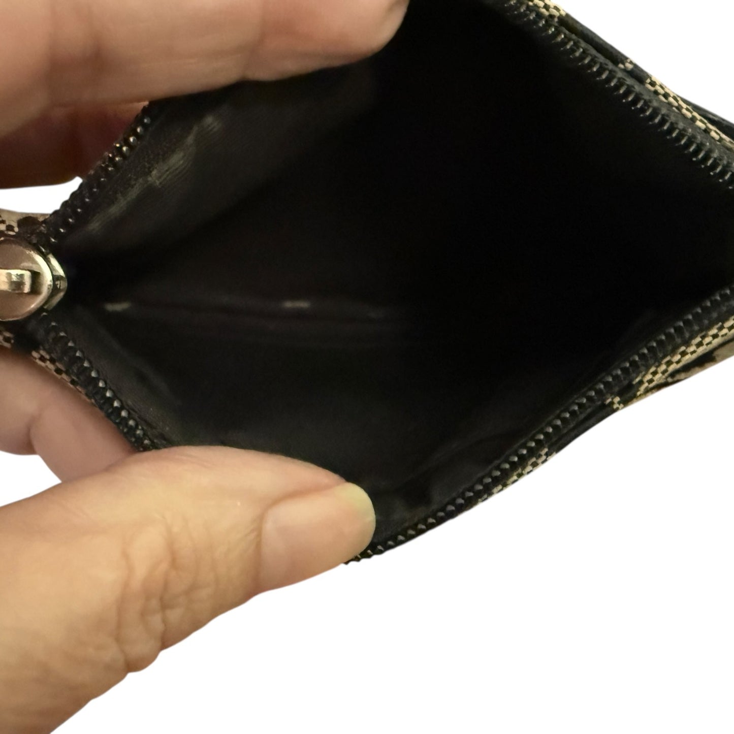 Hand holding an open black wallet with a gold zipper.
