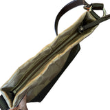 Close-up of top of beige bag with a zipper on a white background