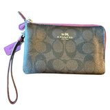 Coach wristlet with CC pattern on a white background