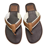 Pair of brown and white flip-flops with Coach logo on a white background