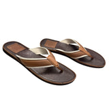 Pair of brown Coach flip-flops on a white background