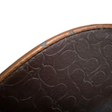 Close-up of a brown leather shoes with embossed pattern and issues on sides on a white background
