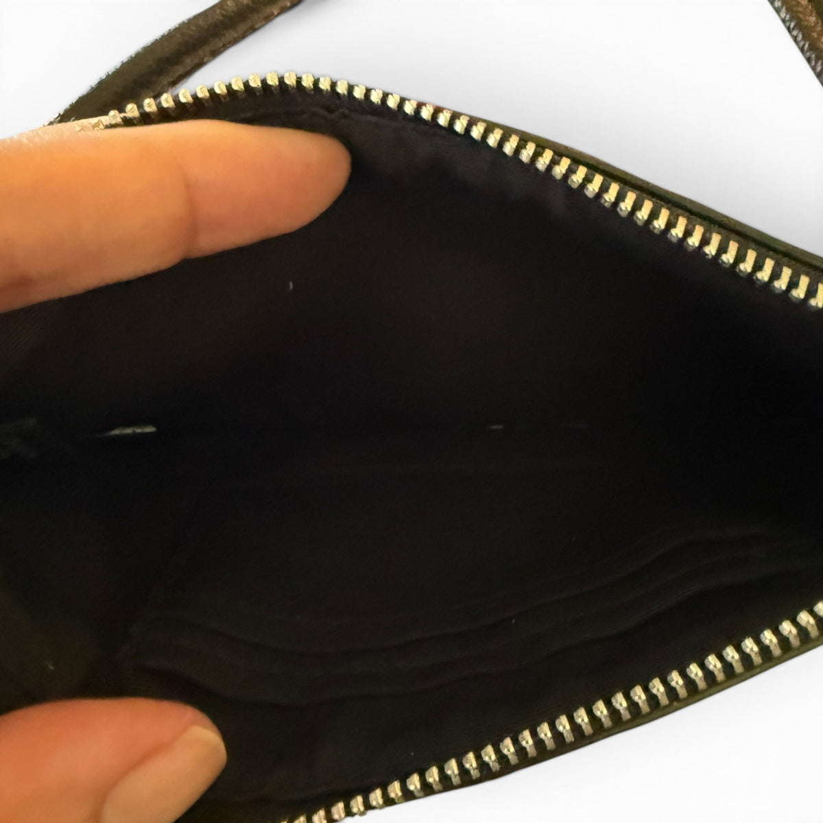 Interior view of wristlet, held open by a hand.