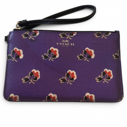 Purple Coach wristlet with floral pattern on a white background