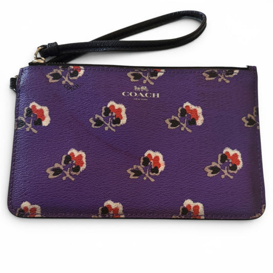 Purple Coach wristlet with floral pattern on a white background
