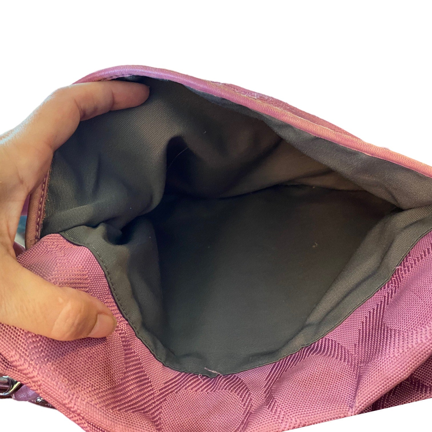 Close-up of a purple bag with a hand opening it, showing the interior.