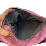 Close-up of a purple bag with a hand opening it, showing the interior.