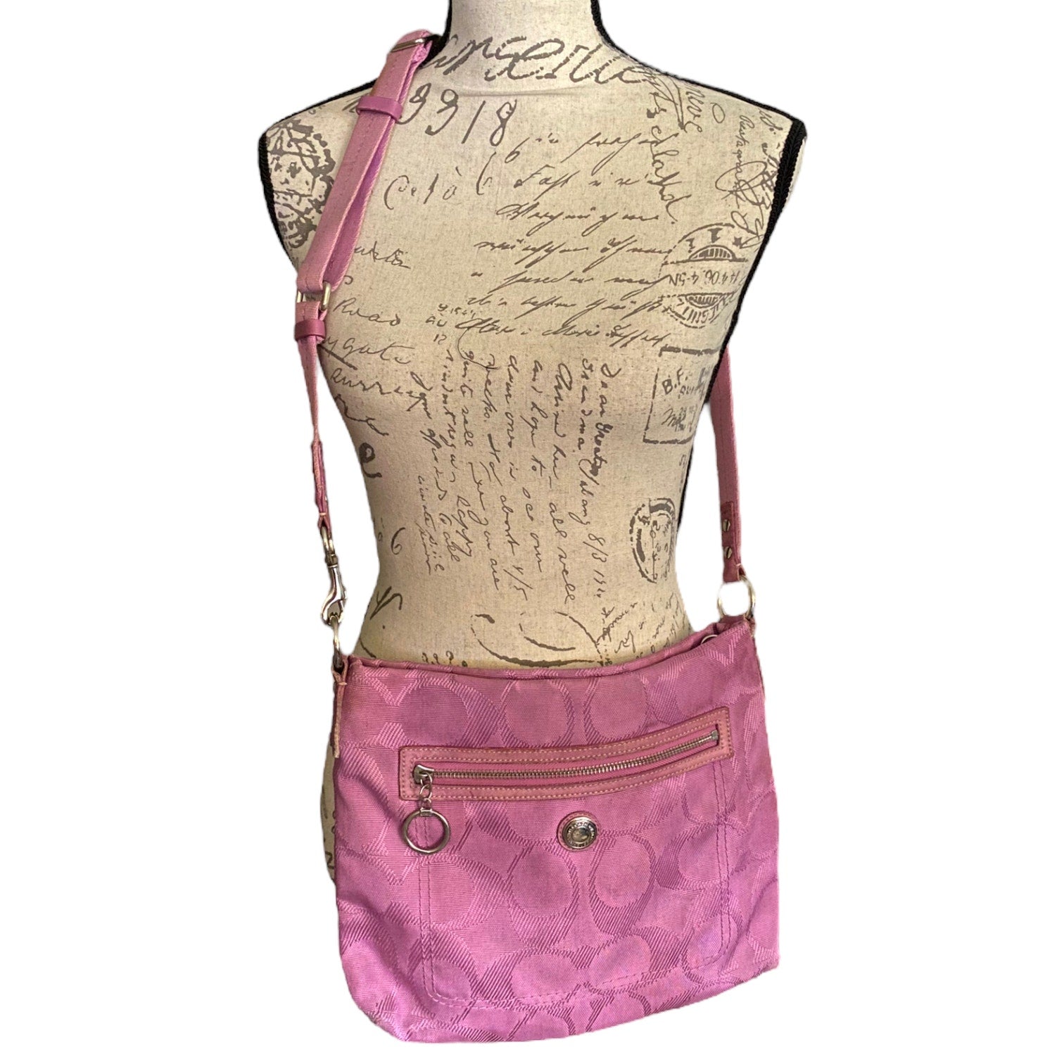 Purple crossbody bag on a mannequin with a script background