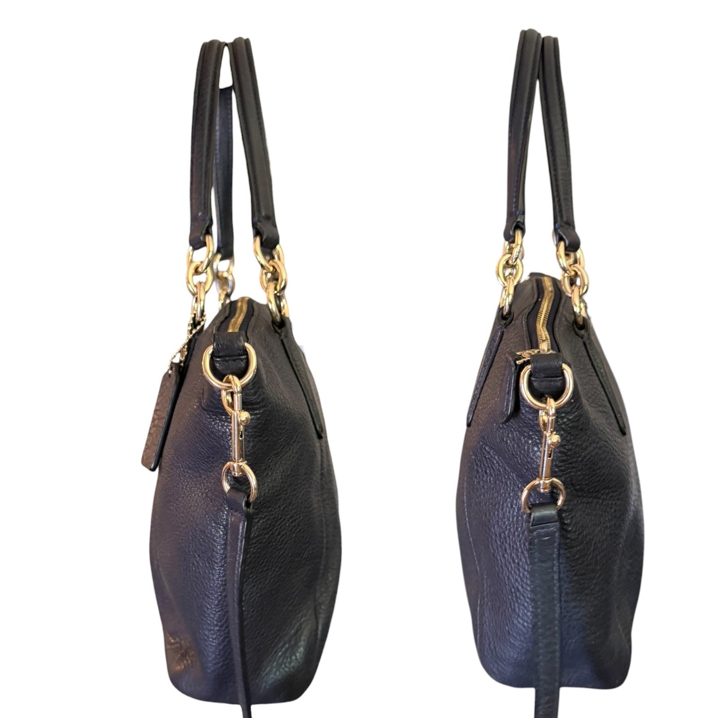 A black pebbled leather handbag shown from two side angles against a plain white background, featuring gold-tone hardware and double top handles.