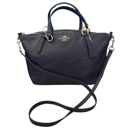 A black pebbled leather Coach handbag , featuring dual top handles, a shoulder strap, and a visible Coach logo on the front.