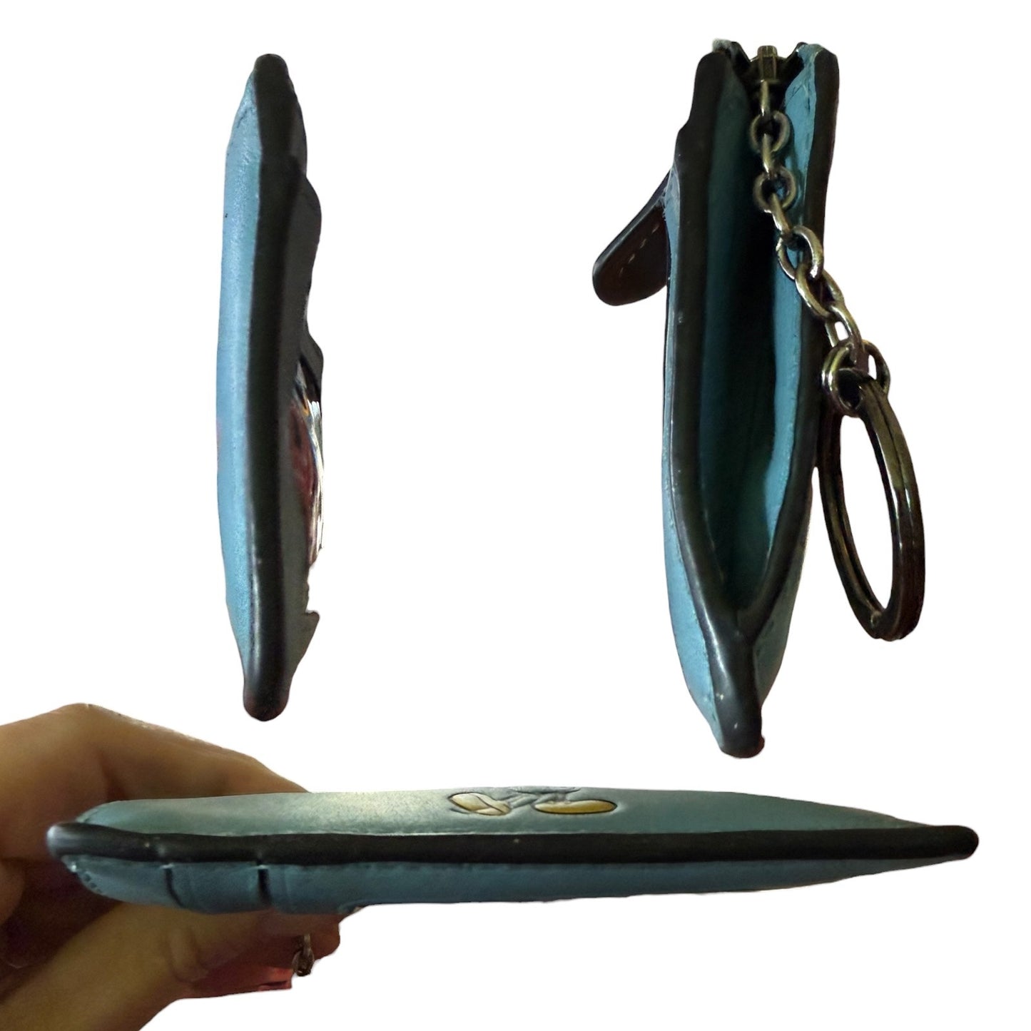 Side views of blue leather wallet  & keychain attachment held by a hand on a white background