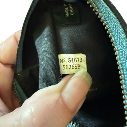 Hand holding a blue leather wallet with a visible gold tag and 'Made in China' label.