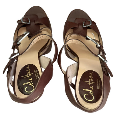 Top of brown sandals with 'Cole Haan' branding on a white background