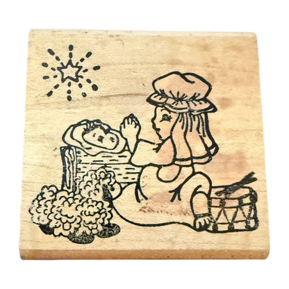 Wooden stamp with a design someone praying over a baby sleeping on a bed.