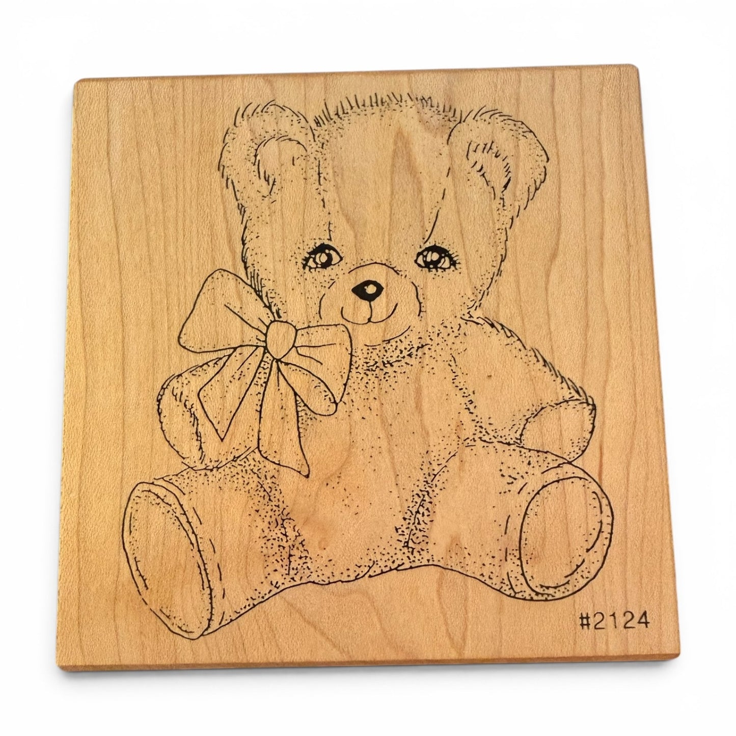 Wooden block with a teddy bear design on a white background