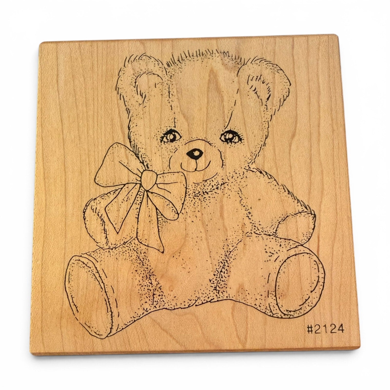 Wooden block with a teddy bear design on a white background