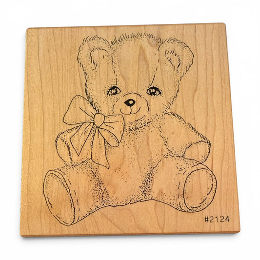 Wooden block with a teddy bear design on a white background