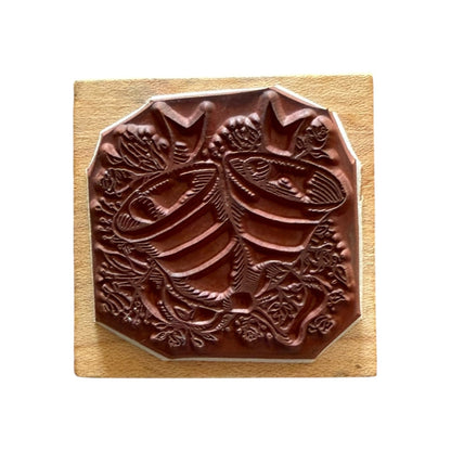 Decorative wooden block with a bells and flower design on a white background