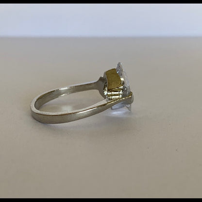 Side view of faux diamond ring on a light background