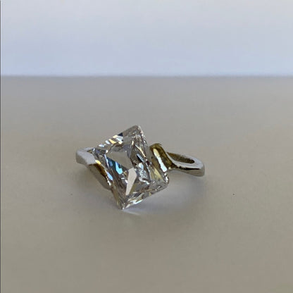 Faux Diamond ring on a beige surface with a white background