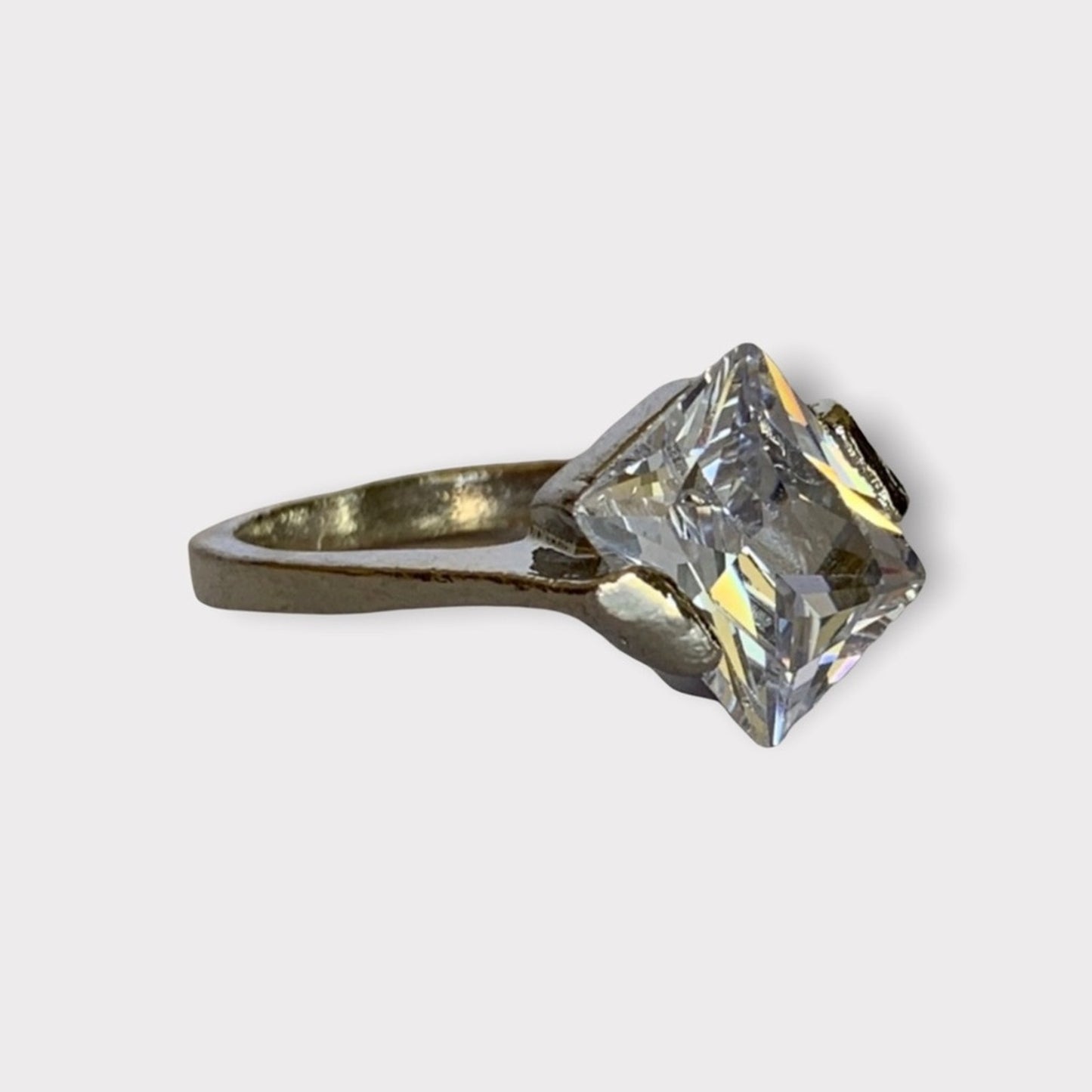 Faux Diamond ring from side on a light gray background