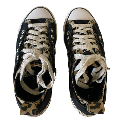 Pair of black low-top sneakers with white laces and animal pattern on a white background